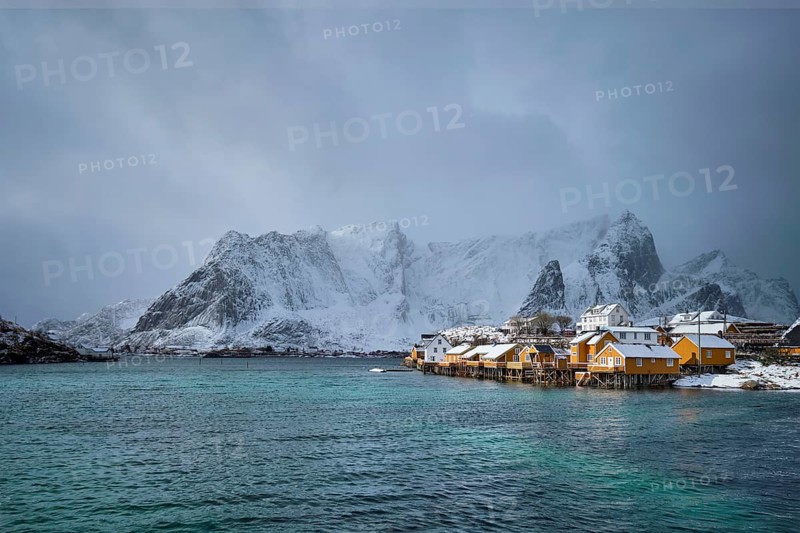 Yellow rorbu houses of Sakrisoy fishing village with snow in winter. Lofoten islands