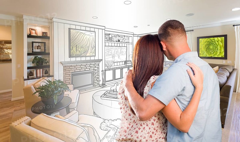 Curious young military couple looking over custom living room design drawing photo combination