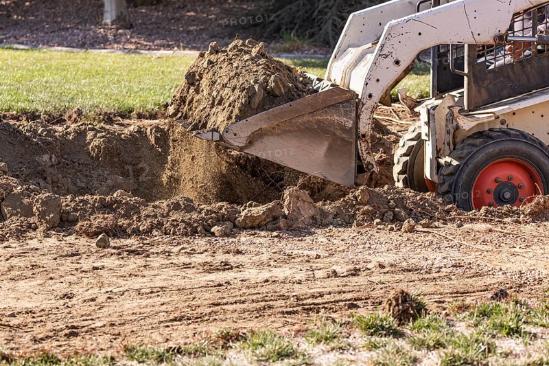 Small bulldozer digging in yard for pool installation
