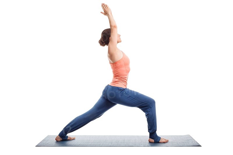Beautiful sporty fit yogini woman practices yoga asana Virabhadrasana 1
