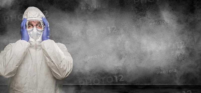 Man wearing hazmat suit and goggles in smokey room banner with copy space