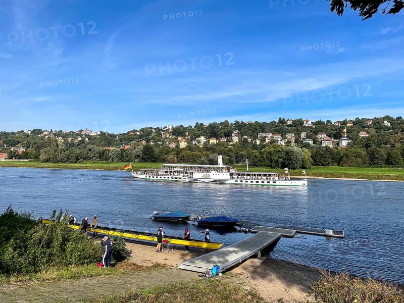 View over a rowing club and boat jetty to the Elbe and a steamer