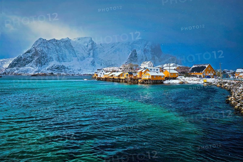 Yellow rorbu houses of Sakrisoy fishing village with snow in winter. Lofoten islands