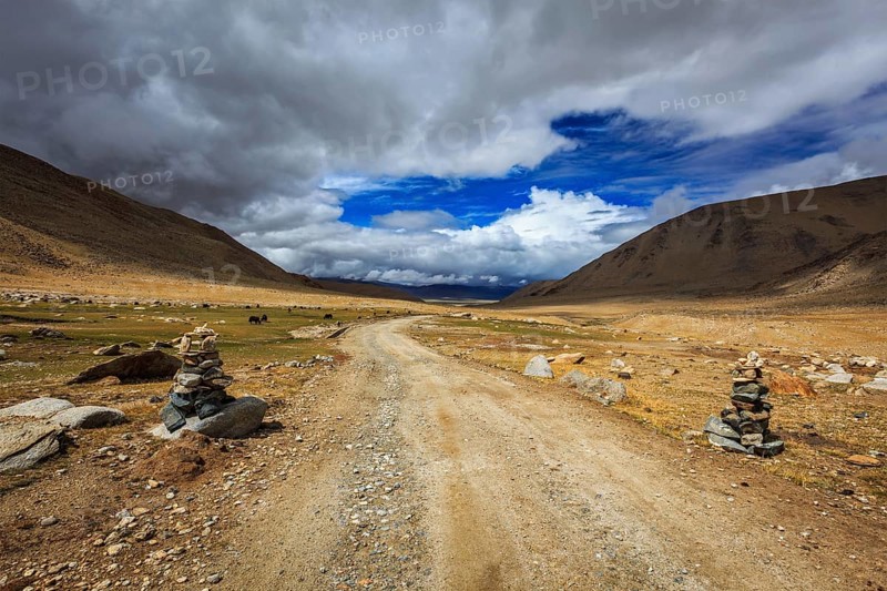 Road in Himalayas with stone cairns. Ladakh