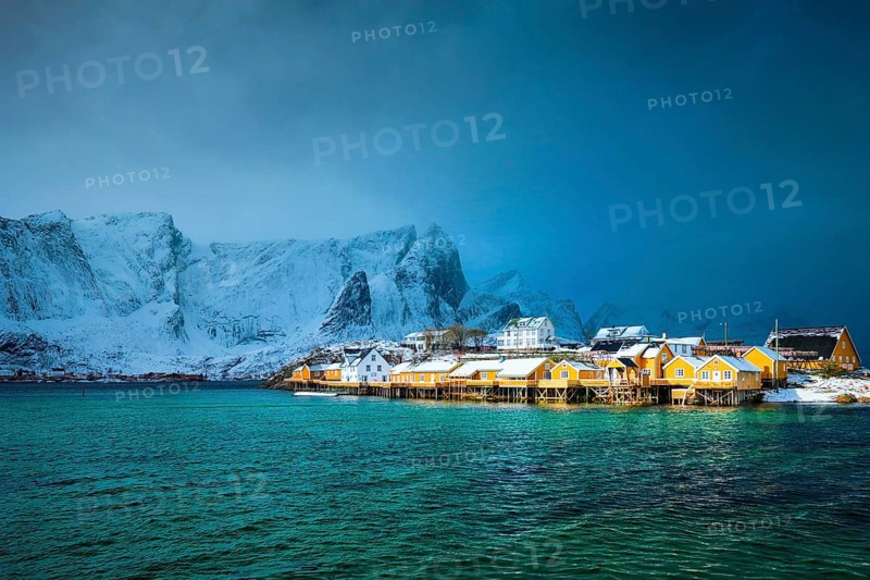 Yellow rorbu houses of Sakrisoy fishing village with snow in winter. Lofoten islands