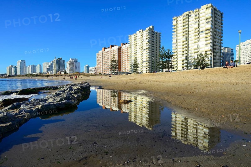 High-rise buildings with flats reflected in the water on the beach