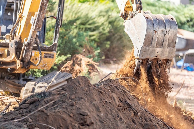 Working excavator tractor digging A trench at construction site
