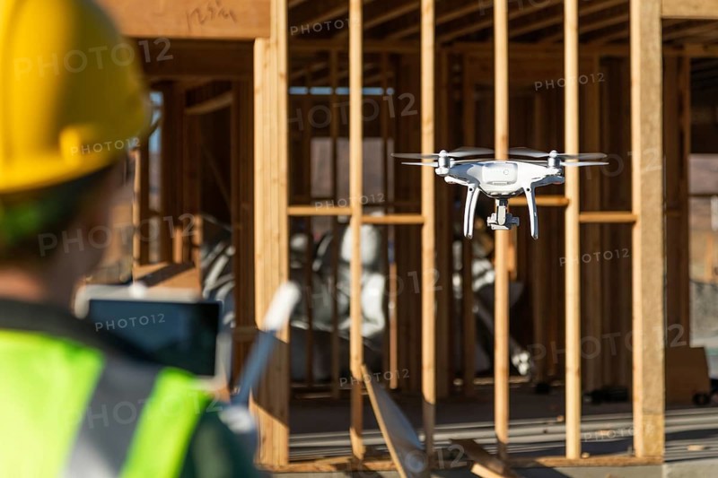 Female pilot flies drone quadcopter inspecting construction site