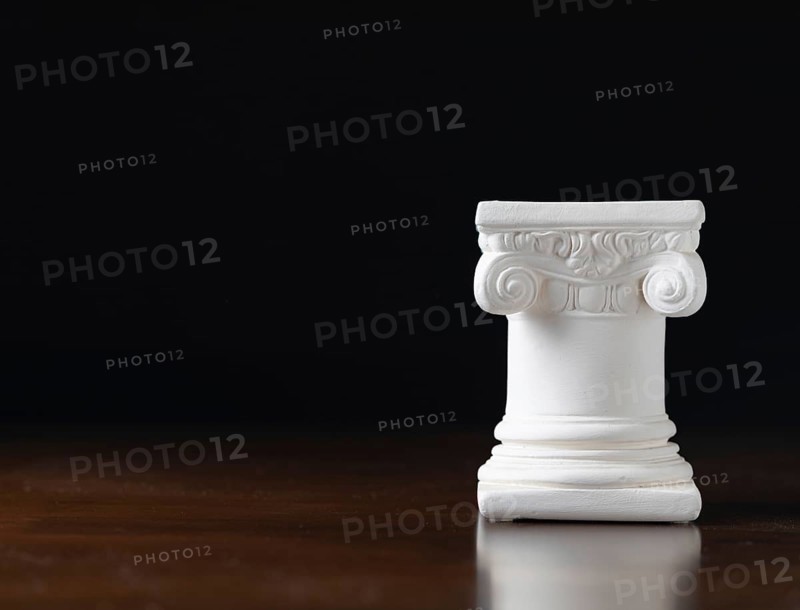 White ionic design column on dark background