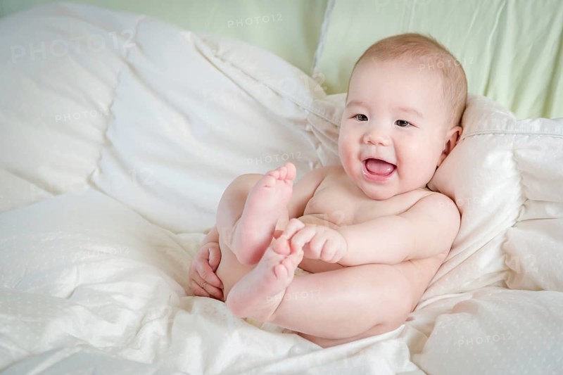 Young mixed-race chinese and caucasian baby boy having fun on his blanket