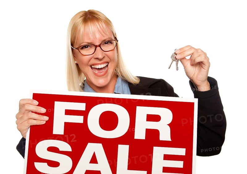 Attractive blonde holding keys & for sale sign isolated on a white background