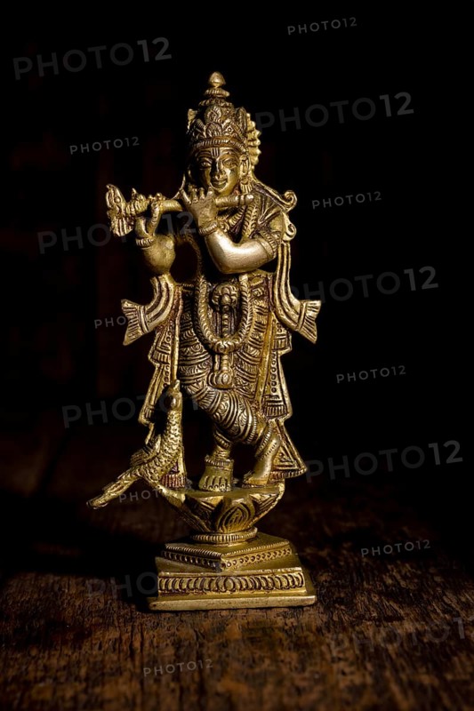 Krishna god Vishnu avatar brass statue isolated on wooden background