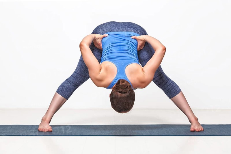 Beautiful sporty fit woman practices Ashtanga Vinyasa yoga asana Prasarita padottanasana B