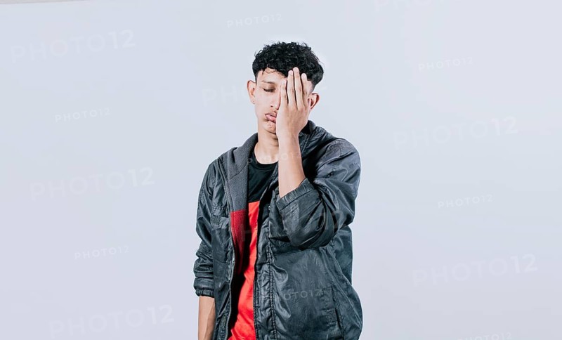 Tired and distressed people covering his face with his palm