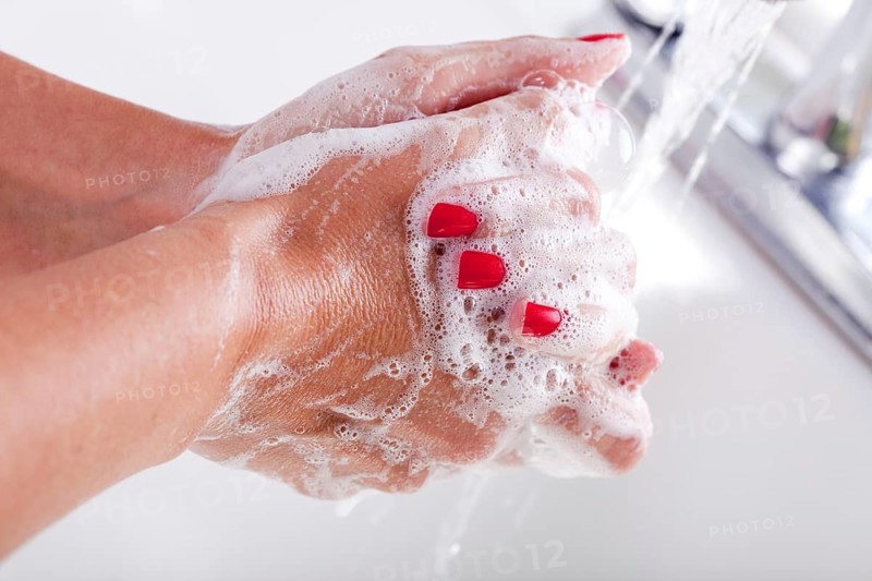 Woman thoroughly washing hands in the sink basin