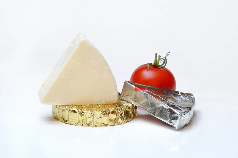 Runder und dreieckiger Schmelzkaese mit Tomate