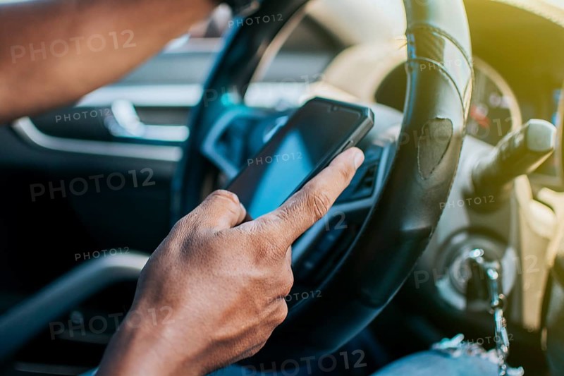 Close up of driver hands using his phone
