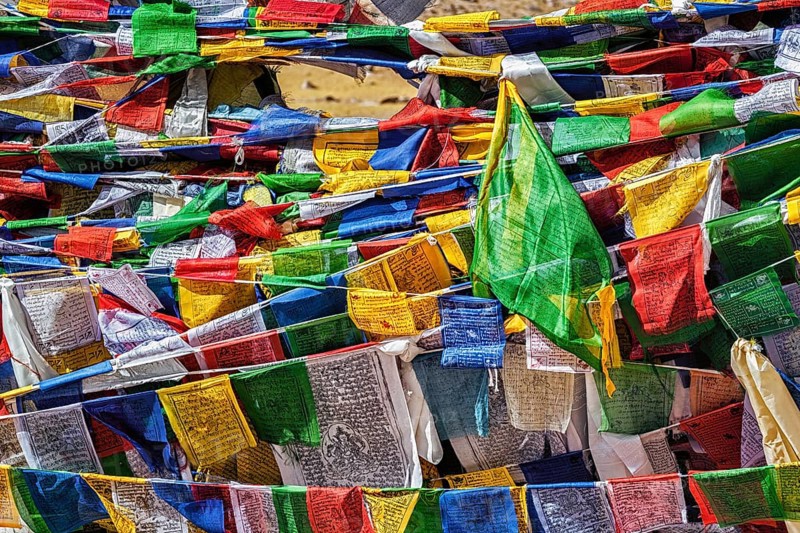 Buddhist prayer flags lungta with mantra Om mani padme hum in tibetan language on Namshang La pass in Himalayas. Ladakh