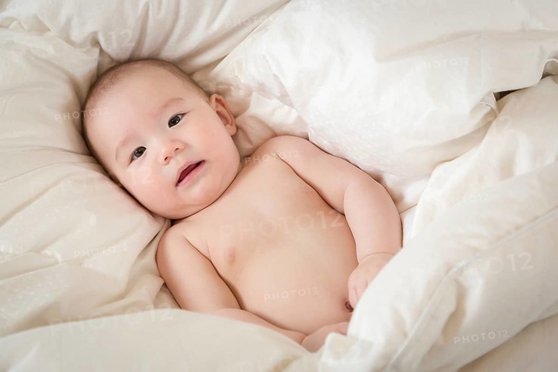 Young mixed-race chinese and caucasian baby boy having fun on his blanket