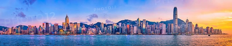 Panorama of Hong Kong skyline cityscape downtown skyscrapers over Victoria Harbour in the evening with junk tourist ferry boat on sunset with dramatic sky. Hong Kong