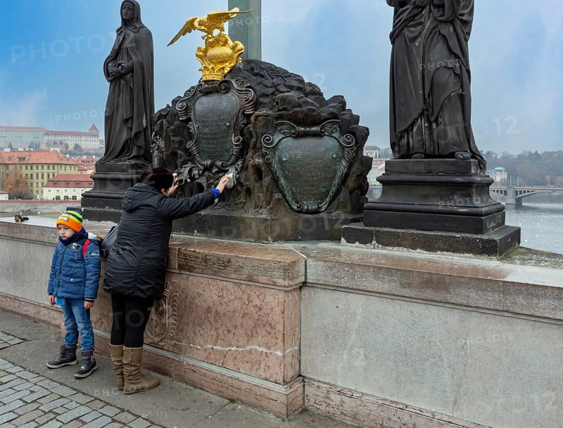 Praying woman with child on Charles Bridge
