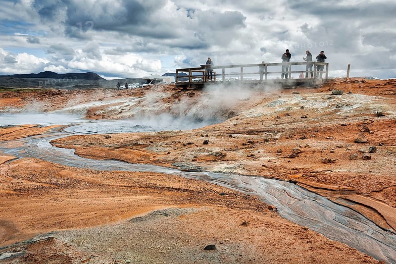 Tourists on viewing platform at steaming mud pot