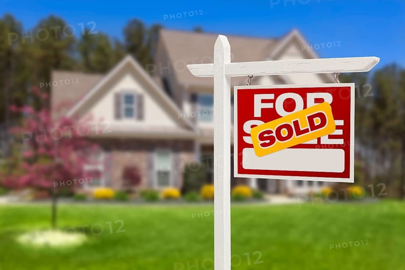 Sold home for sale real estate sign in front of beautiful new house