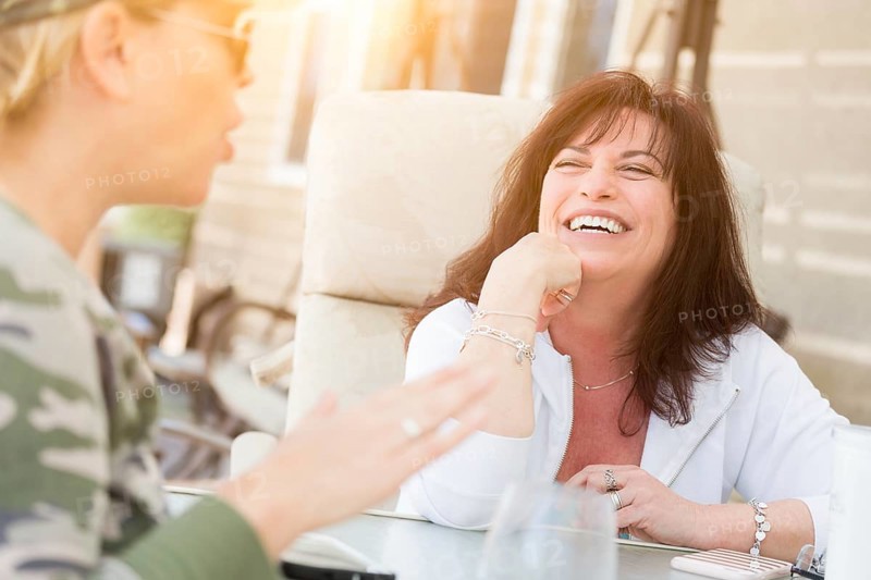 Two female friends enjoying conversation on the patio