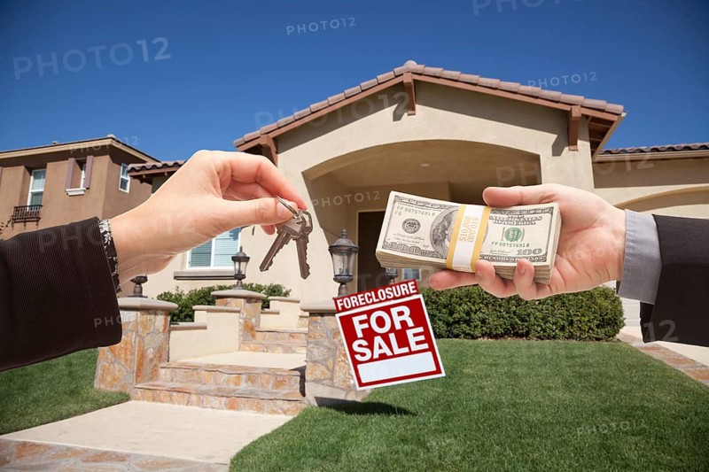 Handing over cash for house keys in front of house and foreclosure sign