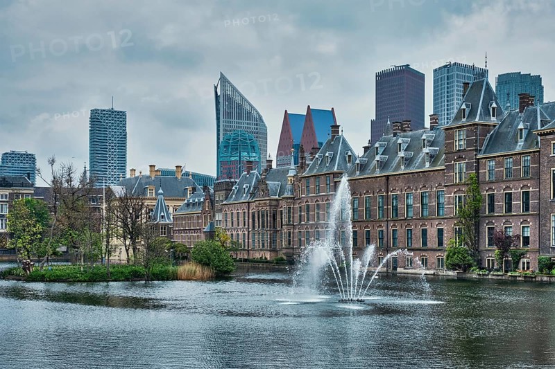 View of the Binnenhof House of Parliament and the Hofvijver lake with downtown skyscrapers in background