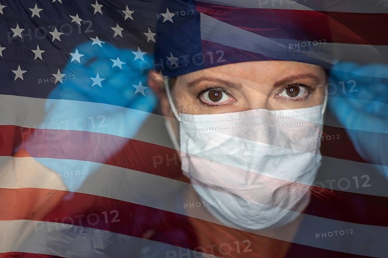 Doctor or nurse wearing medical face mask and scrubs with ghosted american flag