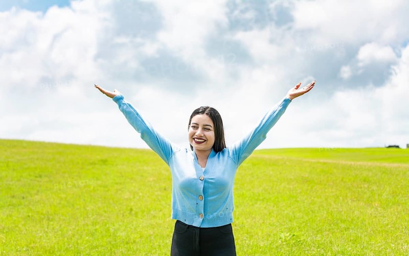 Attractive girl spreading her arms in the field