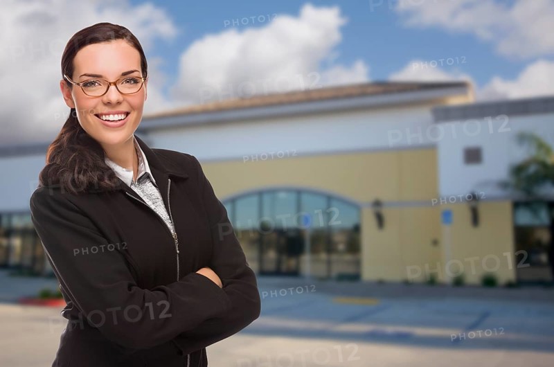 Attractive serious mixed-race woman in front of vacant commercial retail building