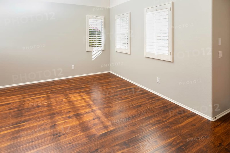 Newly installed brown laminate flooring and baseboards in home