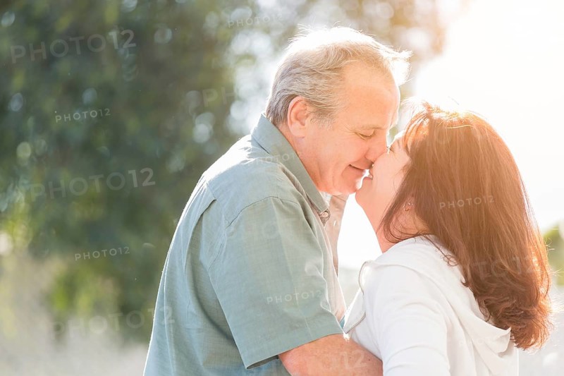 Happy middle aged couple enjoy A romantic slow dance and kiss outside