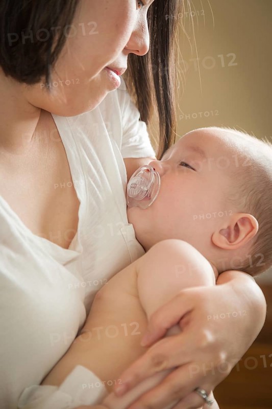 mixed-race chinese and caucasian baby boy being held by his mother