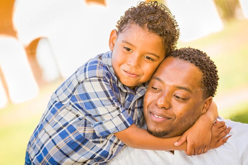 Happy african american father and mixed-race son playing at the park
