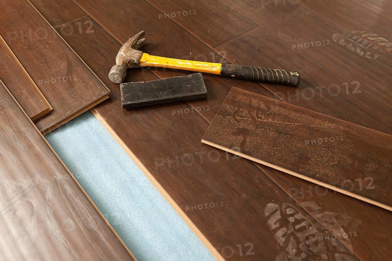 Hammer and block with new laminate flooring abstract