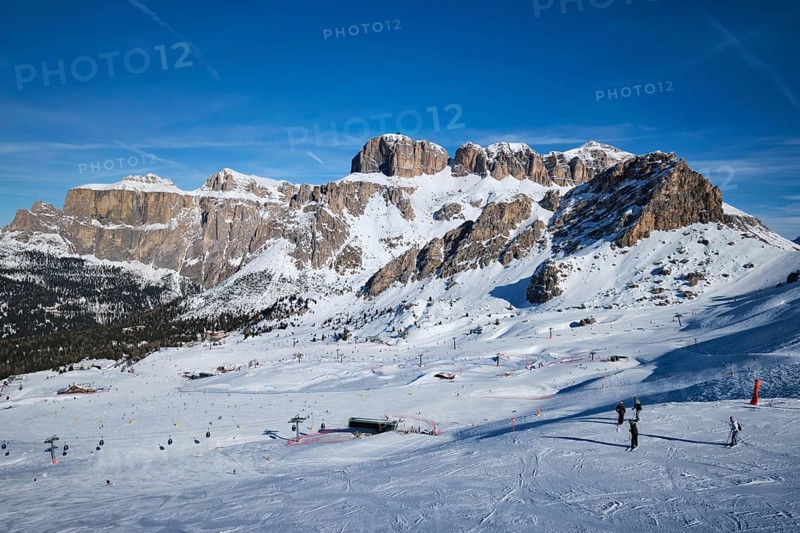 View of a ski resort piste with people skiing in Dolomites in Italy