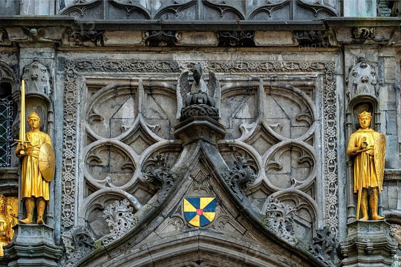 Golden statues and architectural details on the facade above the entrance of the Basilica of the Holy Blood in Bruges