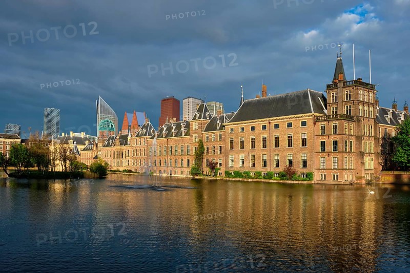 View of the Binnenhof House of Parliament and the Hofvijver lake with downtown skyscrapers in background. The Hague