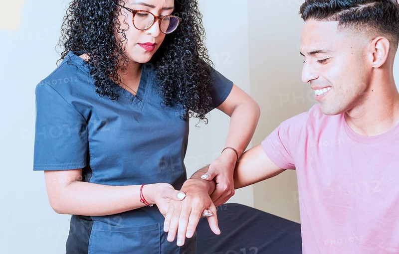 Physiotherapist with patient wrist assessment
