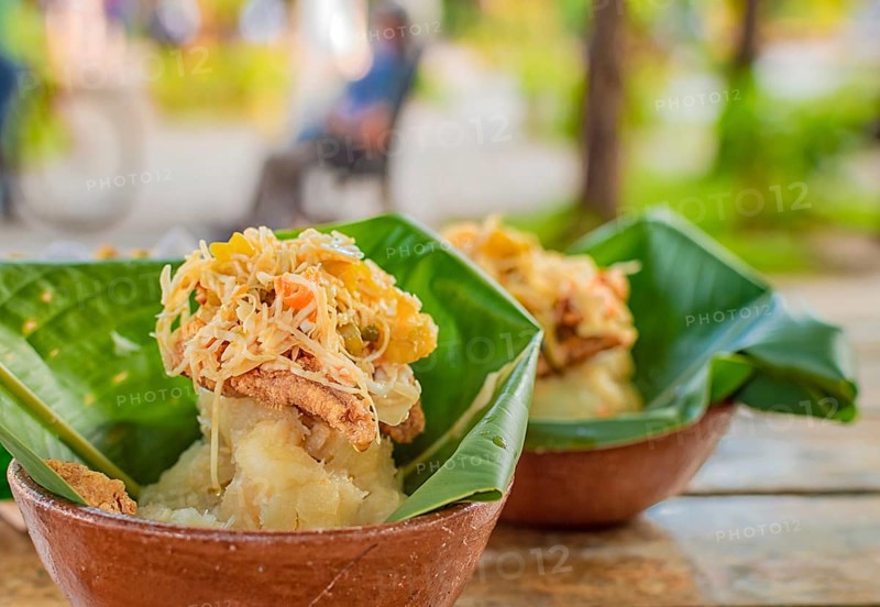 Vigoron with leaves served on a wooden table