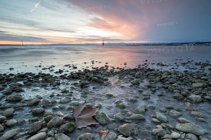 Sunrise on a wintry lake in bad weather