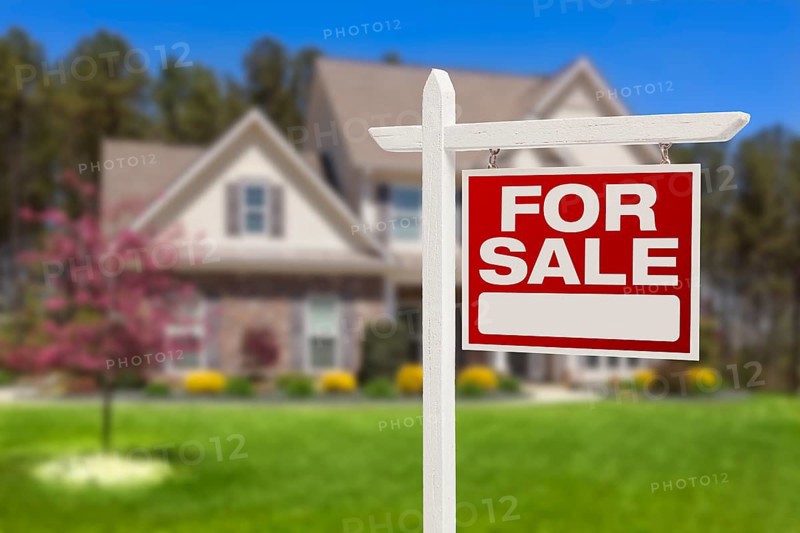 Home for sale real estate sign in front of beautiful new house