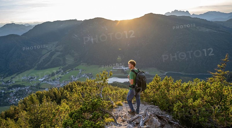 Hiker standing on hiking path between mountain pines