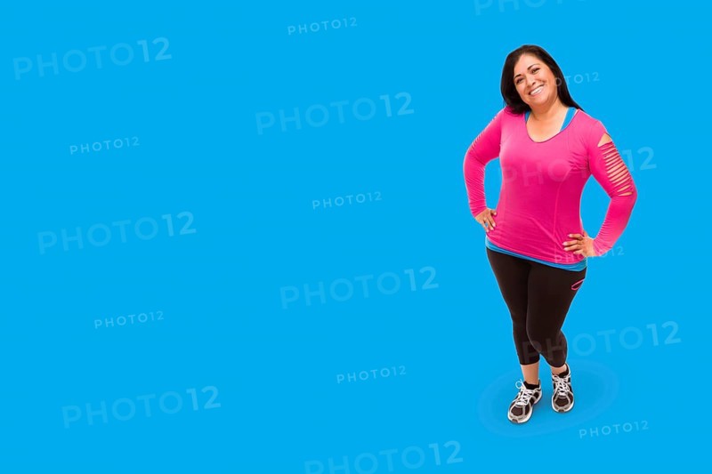 Middle aged hispanic woman in workout clothes against A bright cyan blue background