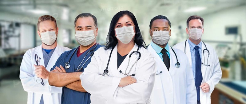 Variety of medical healthcare workers wearing medical face masks amidst the coronavirus pandemic within hospital