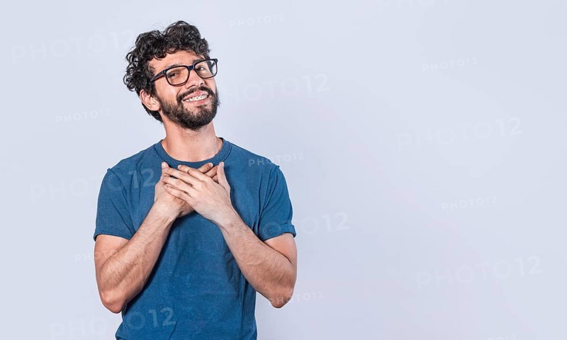 Attractive friendly and positive looking young man with a charming sincere smile feeling grateful