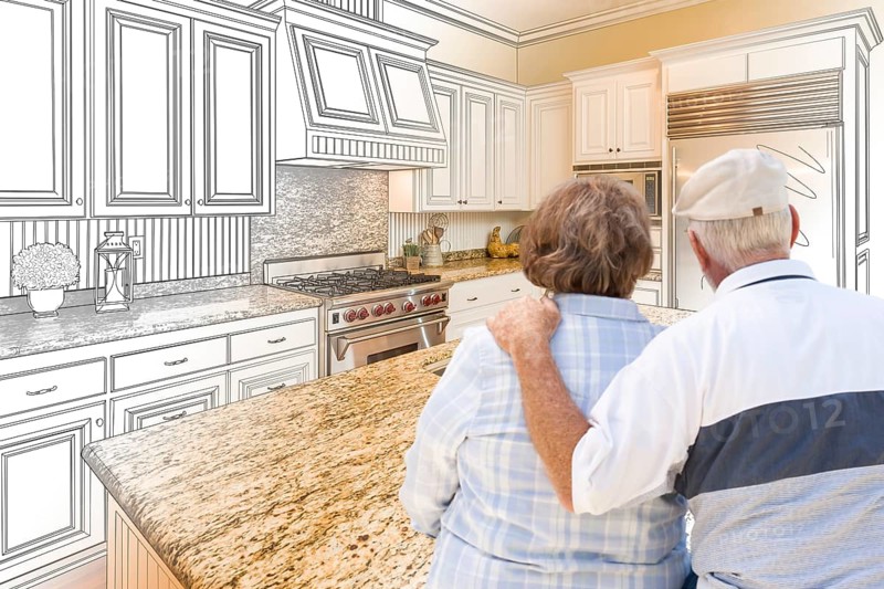 Senior couple looking over custom kitchen design drawing and photo combination